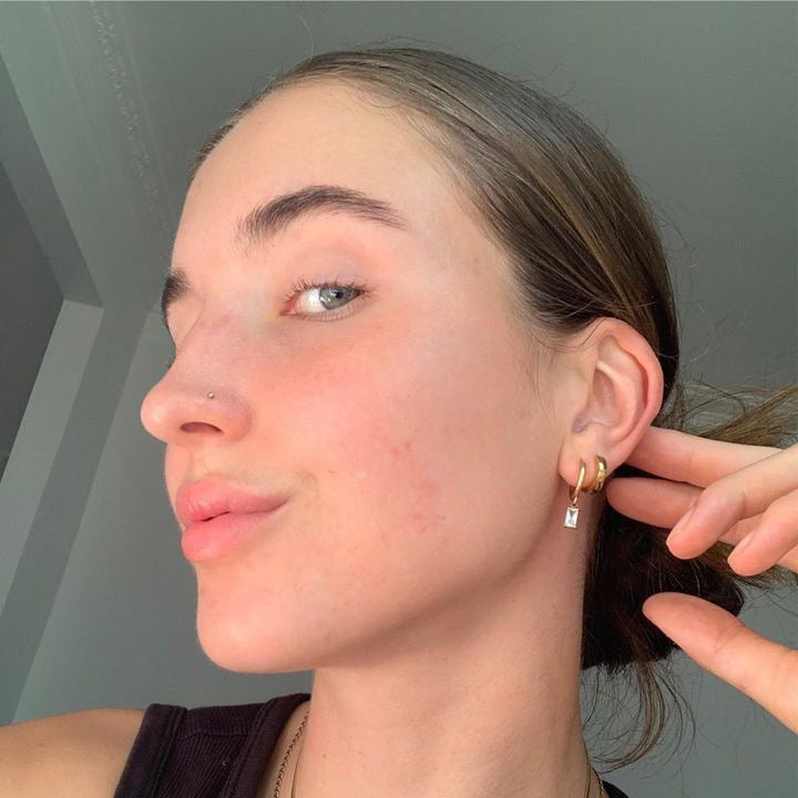 Woman wearing Luxe Drop Gold Earrings with a neutral background
