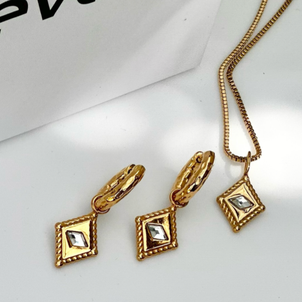 Gold jewelry set with necklace and earrings on a white background