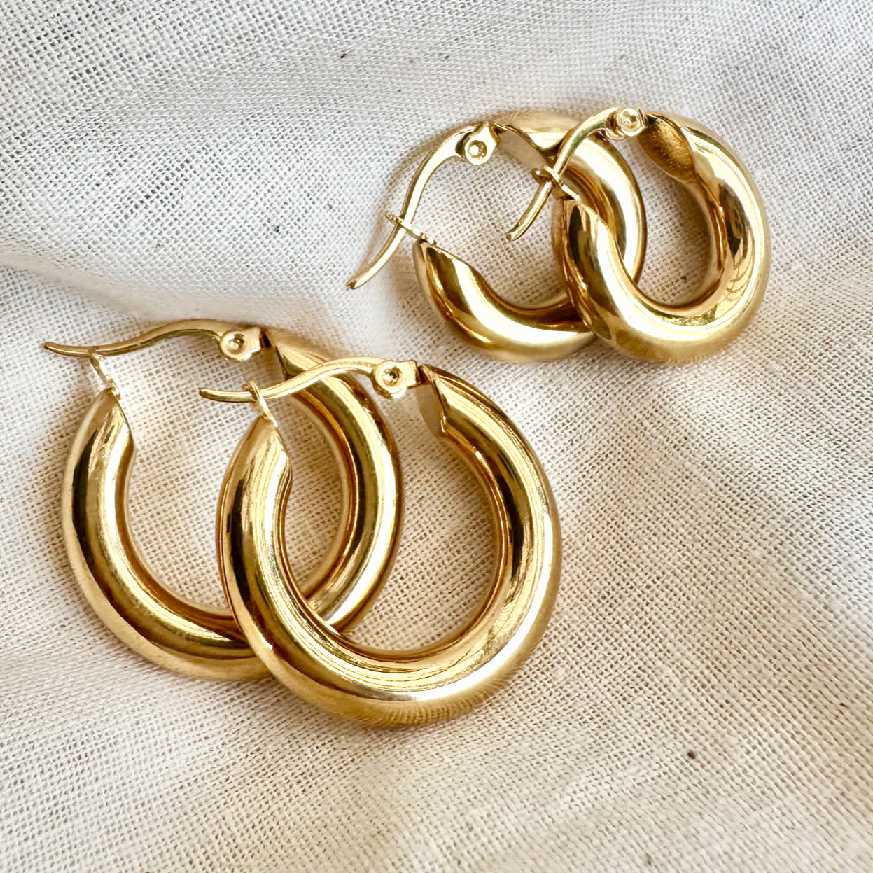 Hustle Hoop Earrings on linen showing the two sizes.