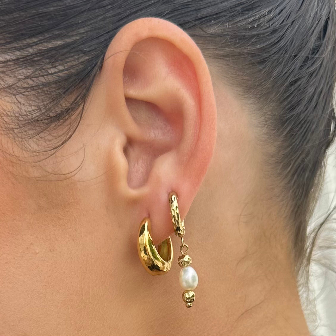 Midnight Run Gold hoop earring with a pearl drop worn by a woman close up to ear