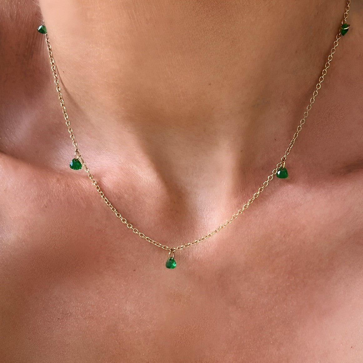 Off Duty Emerald Necklace styled on bare skin – dainty green gem drops and gold chain for a chic look