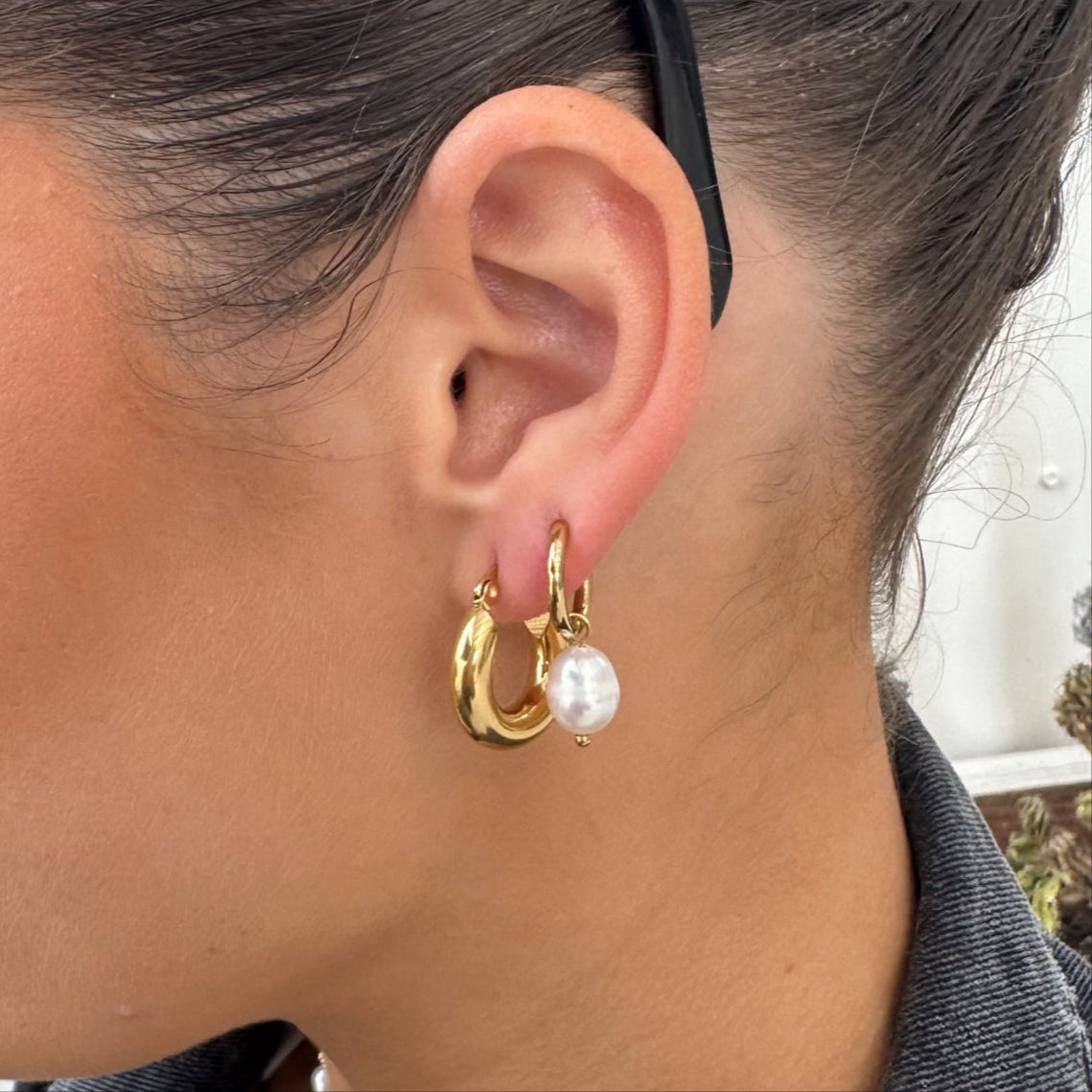 Close-up of woman wearing EVER Jewellery Hustle Hoop Earrings in gold, styled with a pearl drop charm and layered with the After Dark Hoop Earrings.