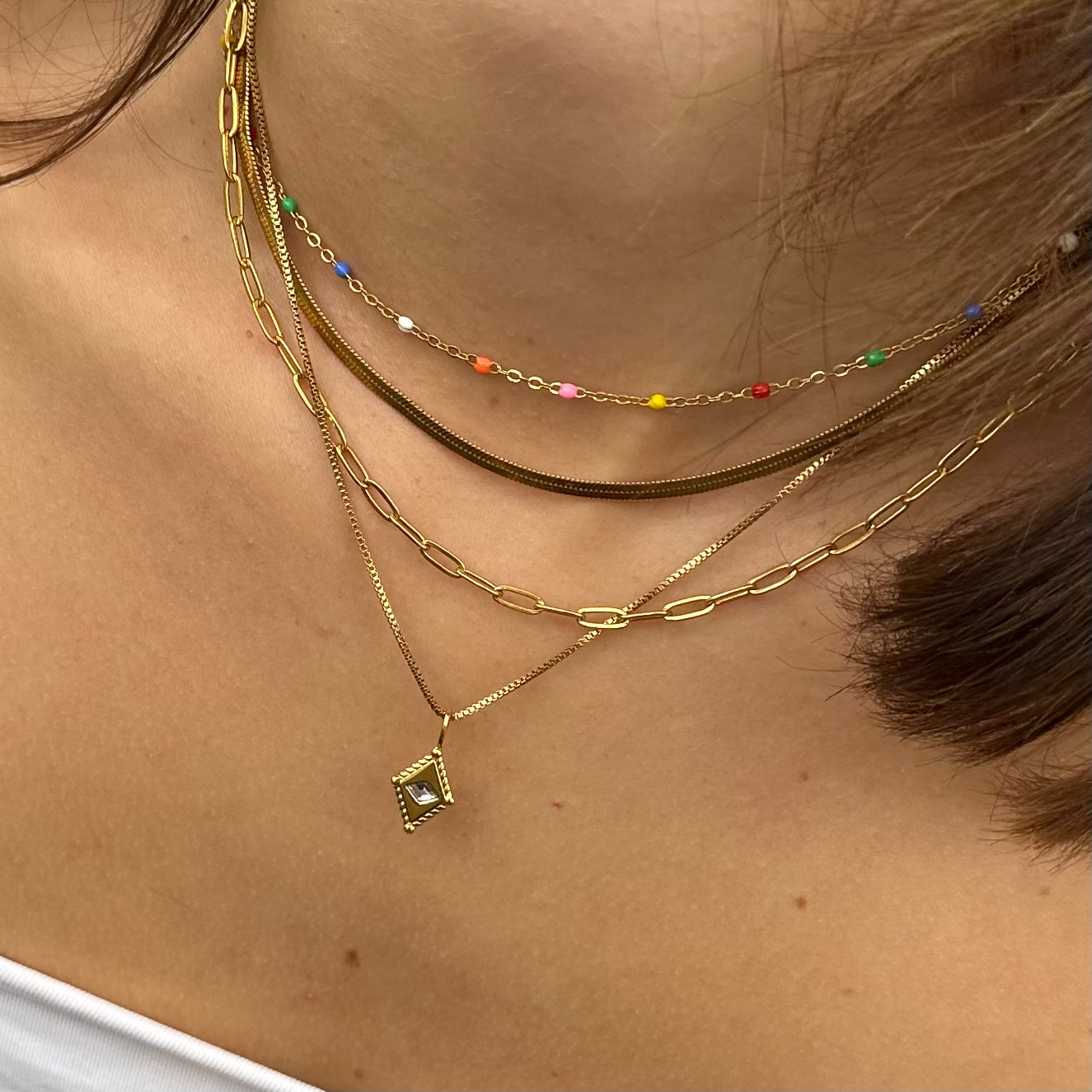 Colour Wave Necklace layered with gold necklaces for a vibrant stack
