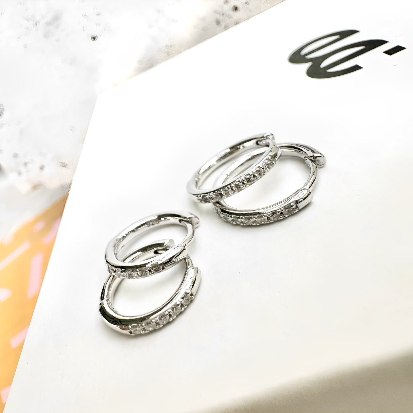Flat lay of Transition Sleeper Silver Earrings bundle on branded jewellery card – 8mm and 10mm hoop sizes