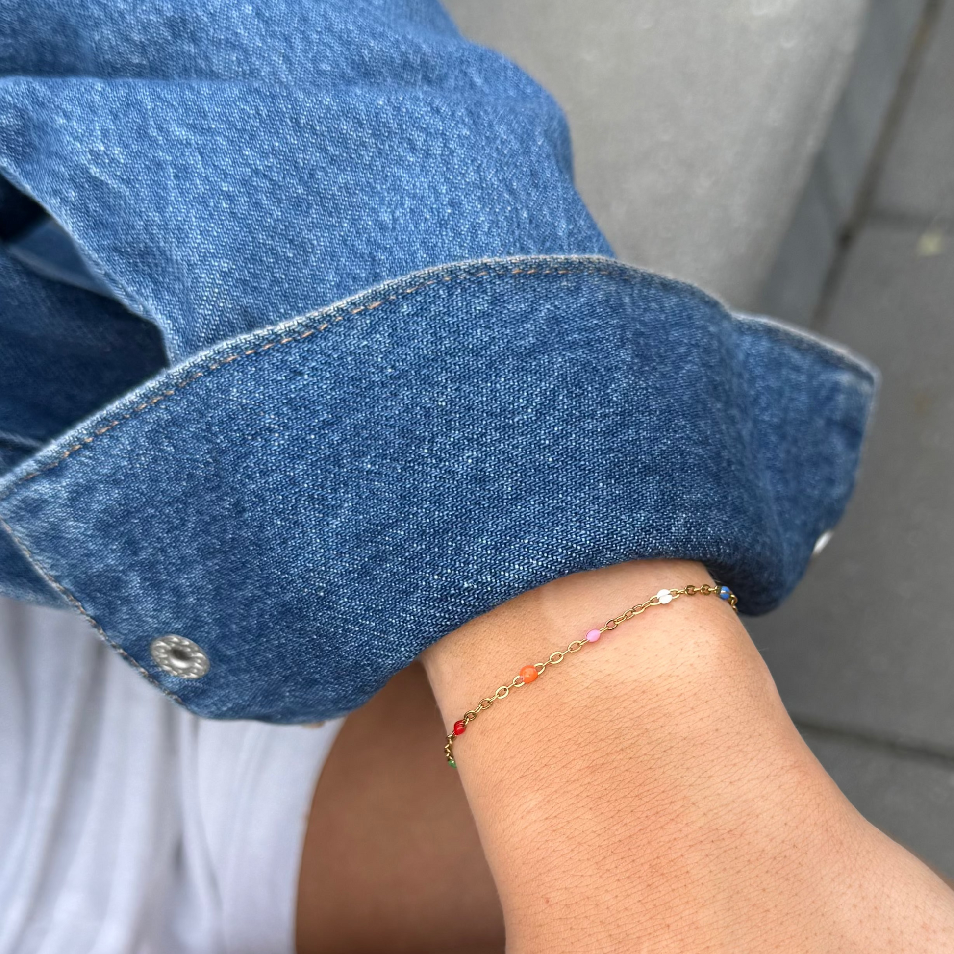 Close-up of a person wearing a colorful bracelet on a blurred background
