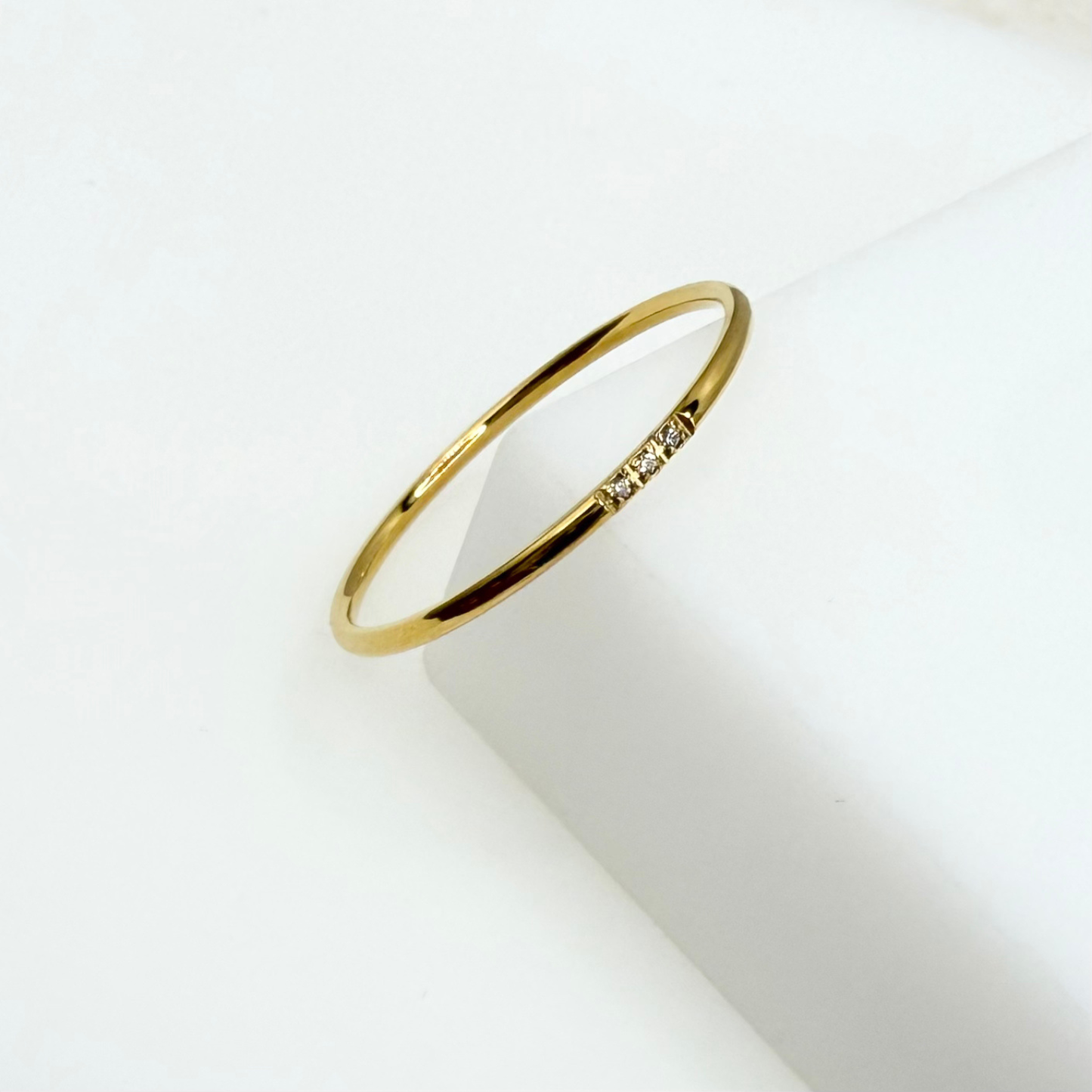 Gold ring with small diamonds on a white background