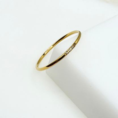 Gold ring with small diamonds on a white background