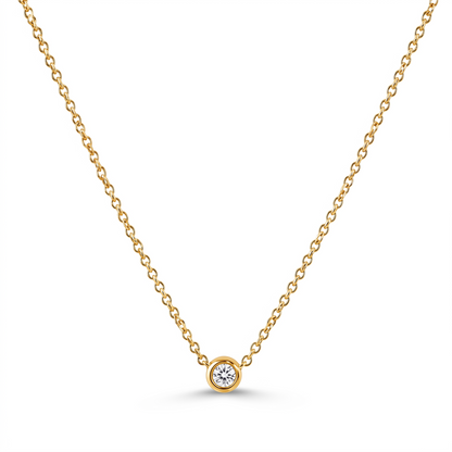 A delicate yellow gold chain necklace with a single bezel-set round diamond pendant, displayed on a clean white background.