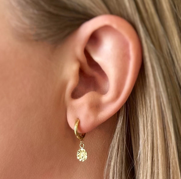 Close-up of Harmony gold huggie earring worn on ear — EVER Jewellery Australia