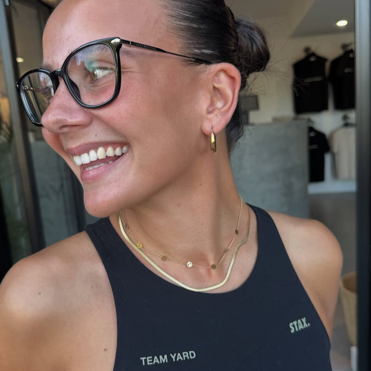 Woman wearing a black tank top with 'TEAM YARD' and 'STAR' branding, smiling.