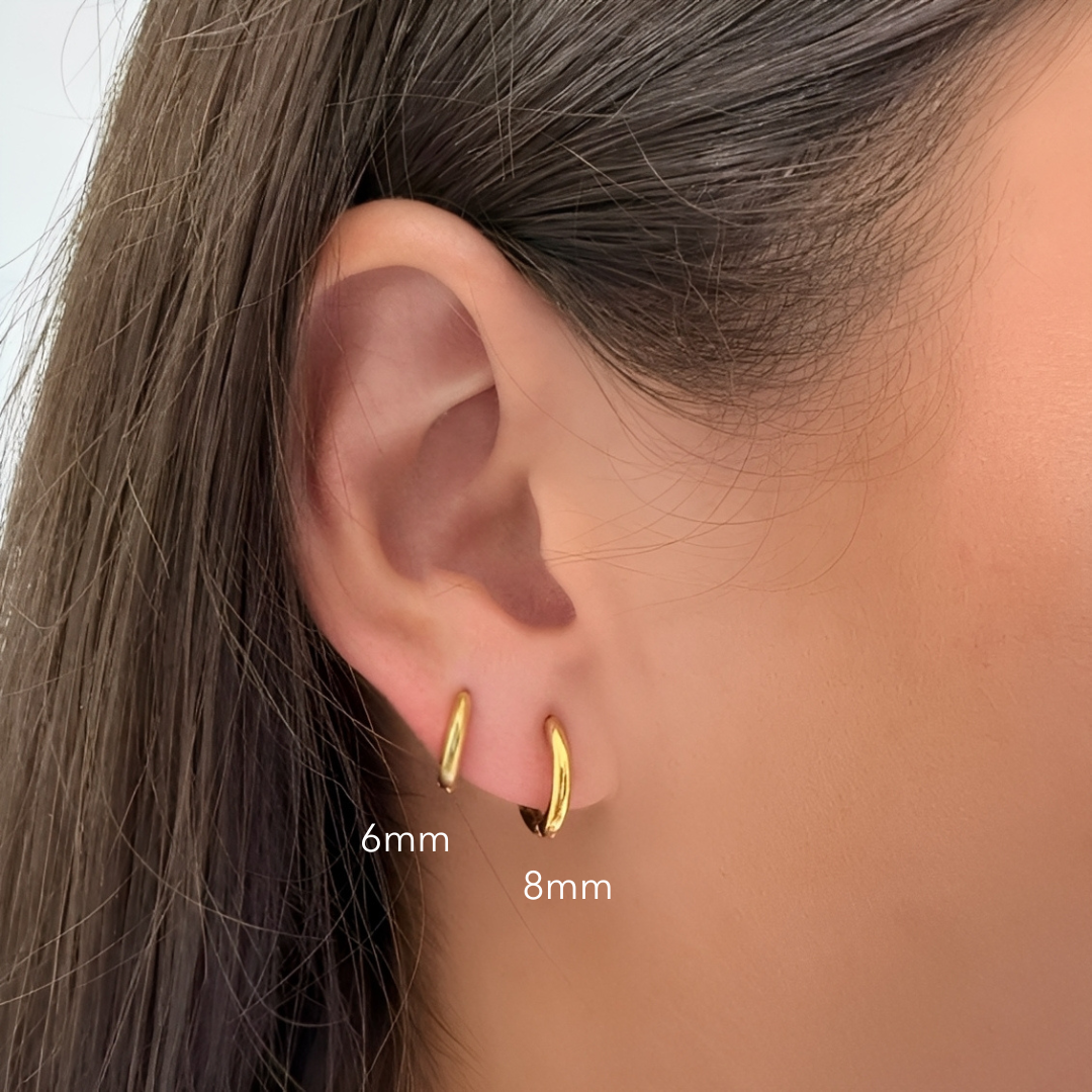 Gold hoop earrings displayed on an ear with size labels '6mm' and '8mm'.
