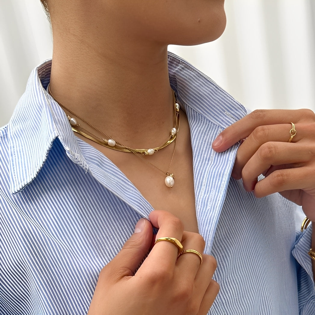 Person wearing a pearl necklace with a white background