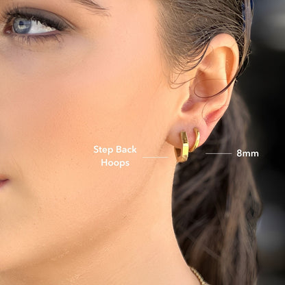 Gold hoop earrings worn by a person with text indicating 'Step Back Hoops' and '8mm'.