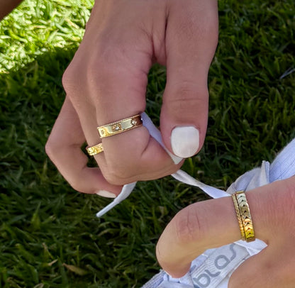 Close-up of hands with gold rings on a grass background