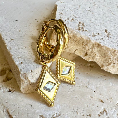 Arena Huggie Earrings – gold earrings with sculpted diamond charms styled on sandstone