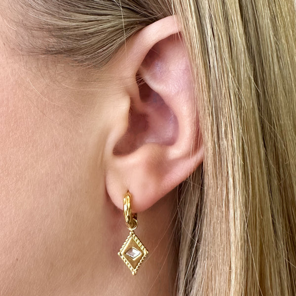 Arena Huggie Earrings worn – close-up of gold earrings with diamond charm on ear