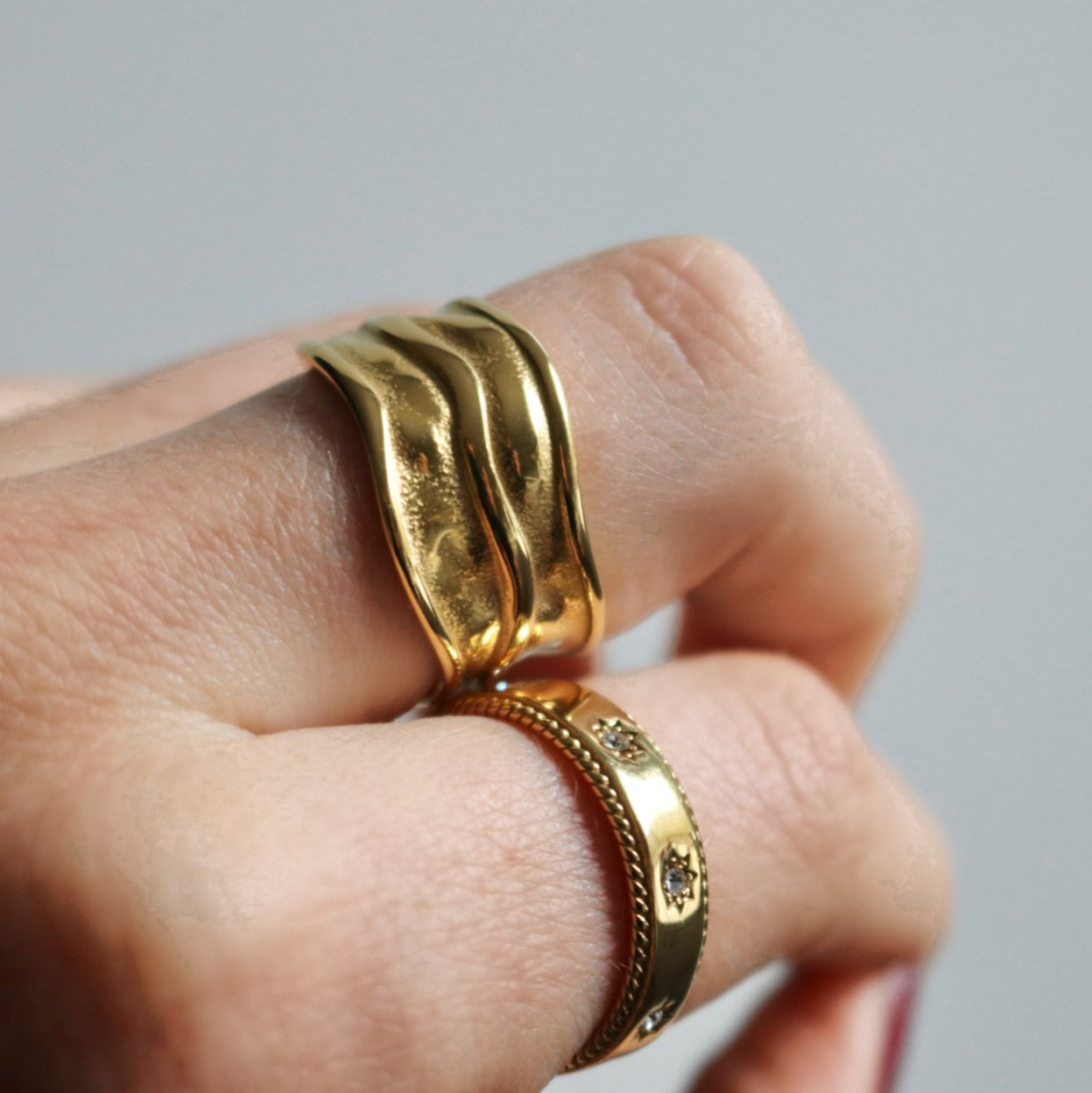 Double Play Ring on hand holding fabric – highlighting bold wave texture