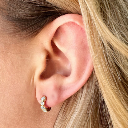 Glory Huggie Earrings styled on ear – minimal hoops made for movement